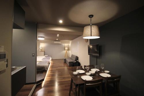 a room with a dining table and a living room at Precioso Umeda Central Osaka - Self Check-In Only in Osaka