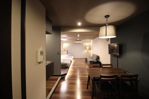 a room with a table and a bed and a couch at Precioso Umeda Central Osaka - Self Check-In Only in Osaka