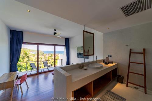 a bathroom with a sink and a counter with a mirror at Folie Bleue Villa in Mae Haad