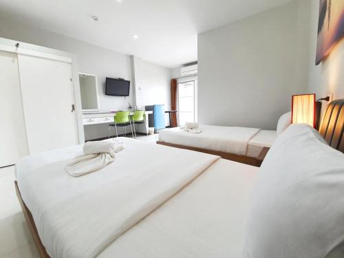 a hotel room with two beds and a tv at Orchid Surin in Surin