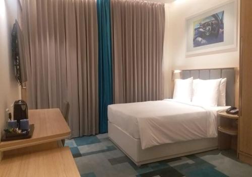 a hotel room with a bed and a table at Holiday Inn Express & Suites Bengaluru Old Madras Road, an IHG Hotel in Bangalore