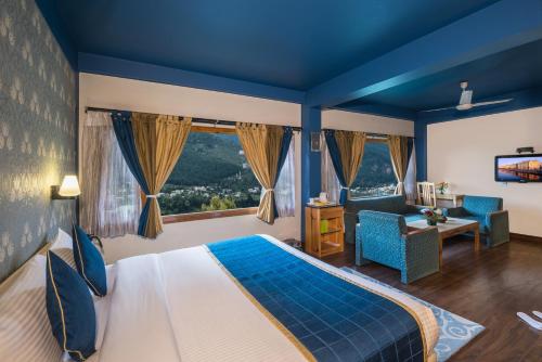 a bedroom with a large bed with a blue ceiling at Honeymoon Inn Manali in Manāli