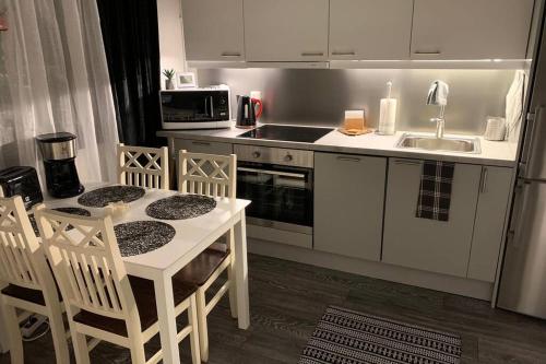 eine Küche mit einer Spüle sowie einem Tisch und Stühlen in der Unterkunft 44m2 yksiö Joensuu in Joensuu