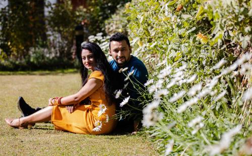 a man and a woman sitting on the grass at Honeymoon Inn Manali in Manāli
