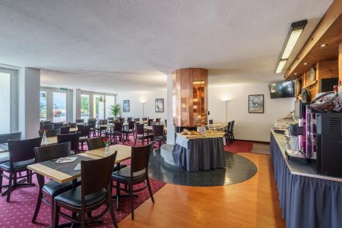 a restaurant with tables and chairs in a room at Hotel Bernerhof in Interlaken