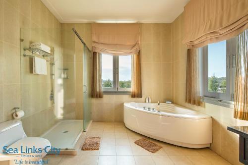 y baño grande con bañera y ducha. en Sea Links Villa Resort & Golf en Mui Ne