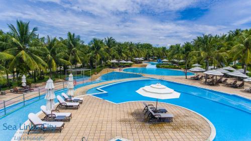 uma imagem de uma piscina de resort com cadeiras e guarda-sóis em Sea Links Villa Resort & Golf em Mui Ne