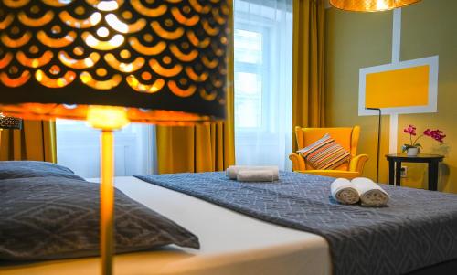 ein Schlafzimmer mit einem Bett mit zwei Handtüchern und einer Lampe in der Unterkunft Highlight Suite Donaustadt in Wien