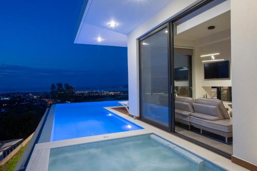 a house with a swimming pool at night at ioniangems in Lefkada Town