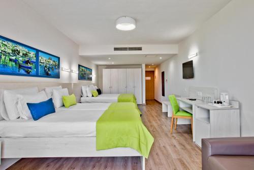 Habitación de hotel con 2 camas y escritorio en Hotel Santana, en St Paul's Bay