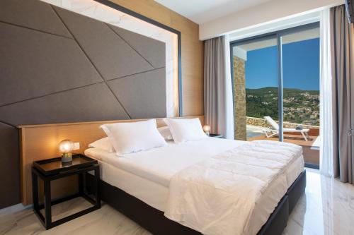 a bedroom with a large bed and a large window at ioniangems in Lefkada Town
