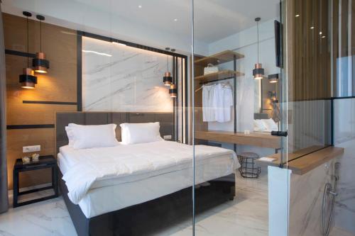 a bedroom with a bed and a glass wall at ioniangems in Lefkada Town