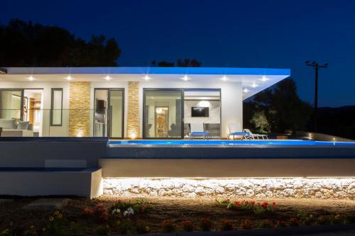 a house with a pool in front of it at night at ioniangems in Lefkada Town