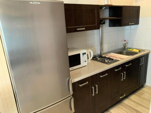 cocina con nevera de acero inoxidable y microondas en Excellent apartment in the center of Odessa, en Odessa