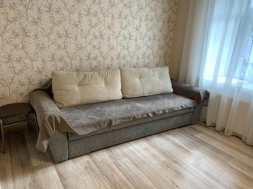 eine Couch in einem Wohnzimmer neben einem Fenster in der Unterkunft Excellent apartment in the center of Odessa in Odessa