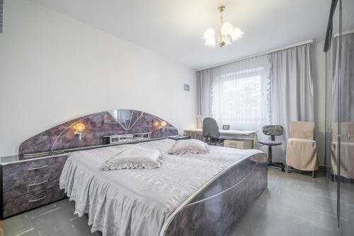 ein Schlafzimmer mit einem großen Bett und einem Schreibtisch in der Unterkunft Privatapartment Stan in Hannover