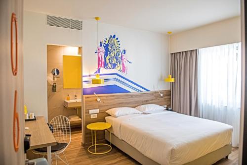 a hotel room with a bed and a table and a desk at ibis Styles Athens Routes in Athens