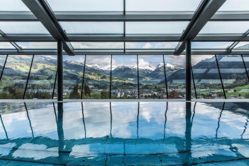 a swimming pool with a view of mountains at Lebenberg Schlosshotel-Kitzbühel in Kitzbühel