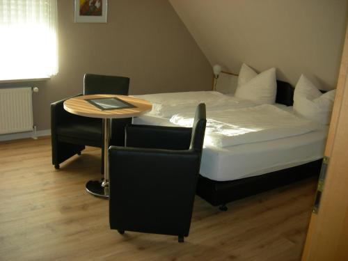 a bedroom with a bed and a table and chairs at Bastan - Haus Katharina in Emden