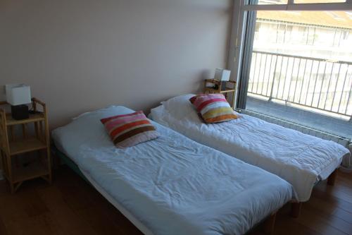 Duas camas num quarto com uma janela em GAMBETTA 2 AVEC LES CLES DE SAINT JEAN DE LUZ em Saint-Jean-de-Luz