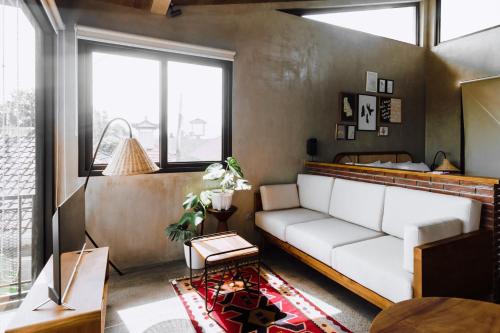 a living room with a white couch and windows at T Lofts in Seminyak