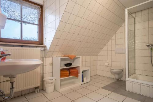 een badkamer met een wastafel, een douche en een toilet bij Ferienwohnung Nr 1 in Deggenhausertal