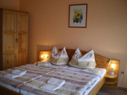 a bedroom with a bed with pillows on it at Mediterrán-Apartmanok-Harkány in Harkány