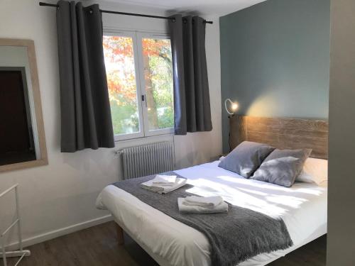 une chambre avec un lit avec deux serviettes dessus dans l'établissement LE NID DE LA PIRAZ - Parking, Balcon & Netflix !, à Annecy