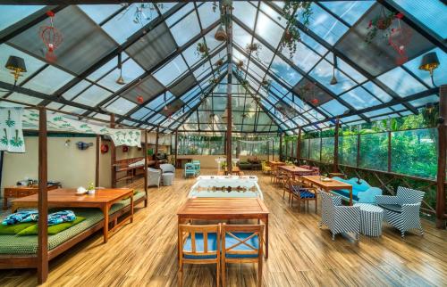 a conservatory with a glass ceiling and tables and chairs at Munjoh Ocean Resort - Private Beachfront Luxury Retreat in Havelock in Havelock Island