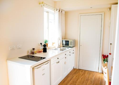 a white kitchen with a sink and a microwave at Desert View in Yeroẖam