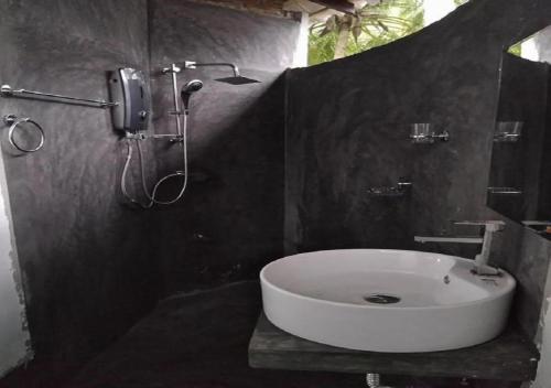 a bathroom with a white sink and a shower at Rice Rice Villas in Tissamaharama