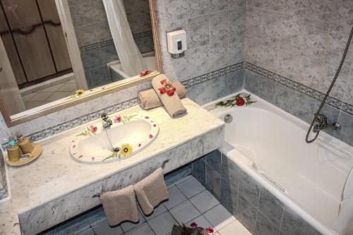 a bathroom with a sink and a bath tub at Hotel Nesrine Hammamet in Hammamet