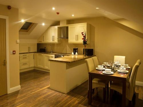 a kitchen with a table and a kitchen with white cabinets at Hillview Self Catering in Lusk