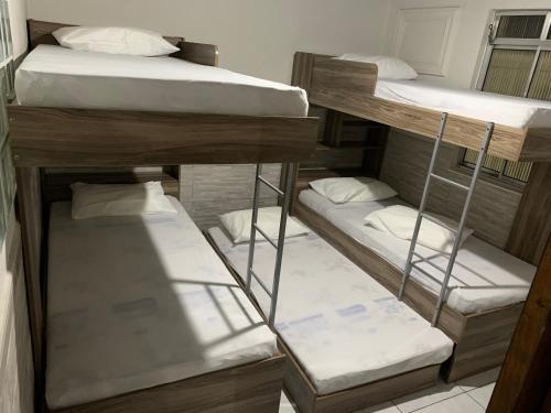 eine Gruppe von Etagenbetten in einem Zimmer in der Unterkunft Linda casa de Veraneio in Guarujá