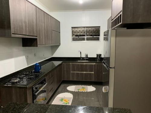 eine Küche mit Kühlschrank und Arbeitsplatte in der Unterkunft Linda casa de Veraneio in Guarujá