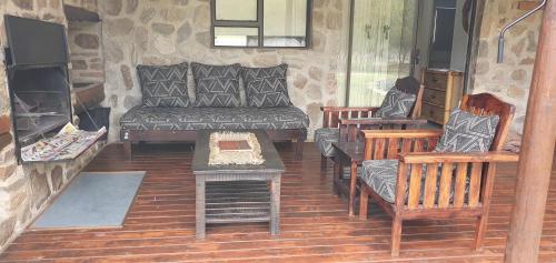 a living room with a couch and chairs and a fireplace at Wagendrift Lodge in Geelwal