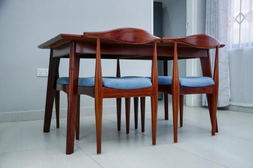 a wooden table with two chairs under it at Greyville Apartments in Lusaka