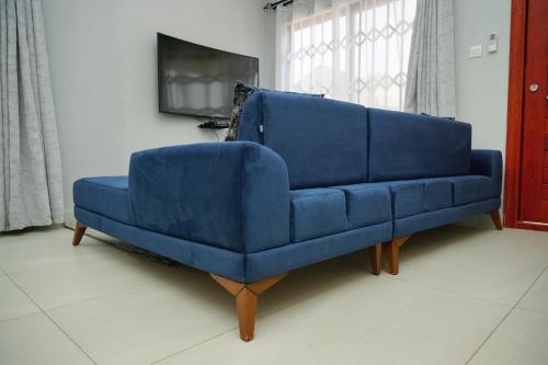 a blue couch sitting in a living room at Greyville Apartments in Lusaka