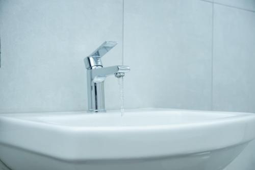 a bathroom sink with a faucet on top of it at Greyville Apartments in Lusaka