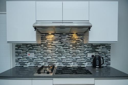 a kitchen with a stove top with a microwave at Greyville Apartments in Lusaka