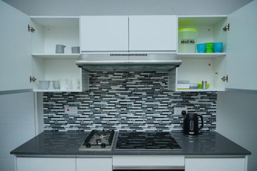a kitchen with a black counter top with a stove at Greyville Apartments in Lusaka
