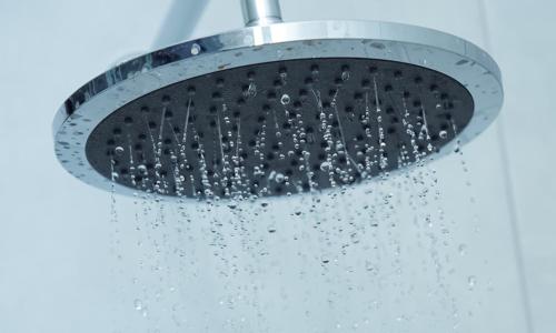 a shower head with water pouring out of it at Greyville Apartments in Lusaka