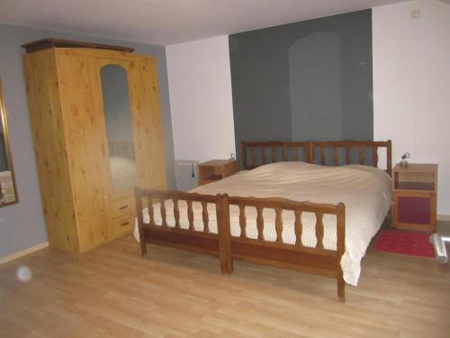 1 dormitorio con cama de madera y puerta de madera en Studio privatif au centre de Lobbes, en Lobbes