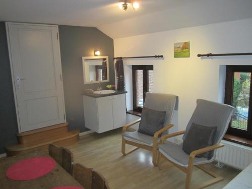 a living room with two chairs and a table at Studio privatif au centre de Lobbes in Lobbes