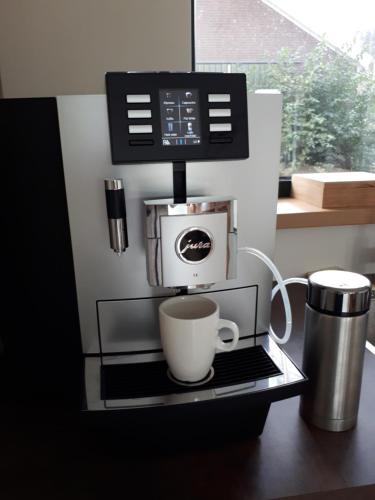 a coffee maker on a shelf with a coffee cup at B&B In de Wei in Erp