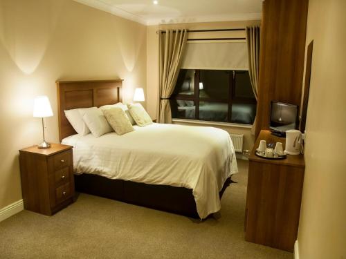um quarto de hotel com uma cama e uma janela em Hillview Self Catering em Lusk