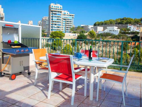un patio con tavolo, sedie e griglia di Apartment Cala Manzanera-2 by Interhome a Calpe