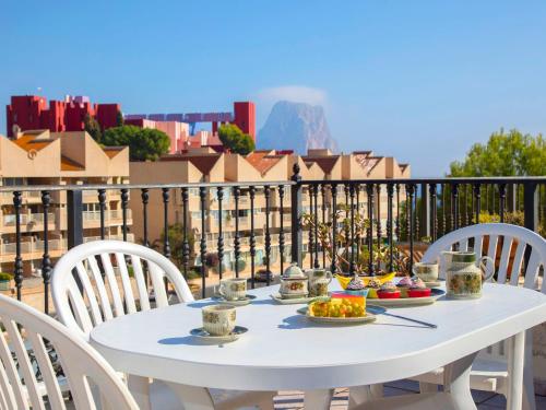 una mesa blanca con platos de comida en el balcón en Apartment Casa Manzanera by Interhome, en Calpe