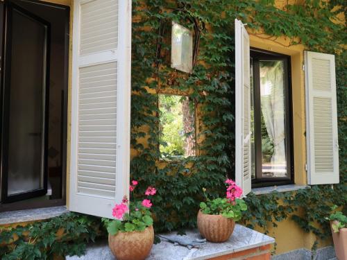 een gebouw met twee ramen met bloemen voor hen bij Holiday Home Atelier-2 by Interhome in Invorio Inferiore
