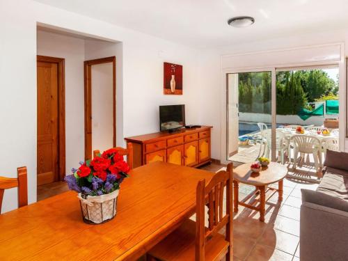 - un salon avec une table en bois et des fleurs dans l'établissement Holiday Home Villa Santa Marta IV by Interhome, à Les tres Cales